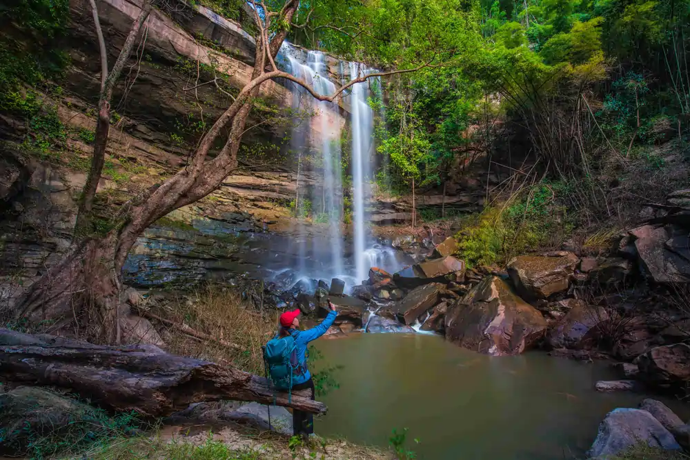 Woman touring a beautiful waterfall in Sri Lanka